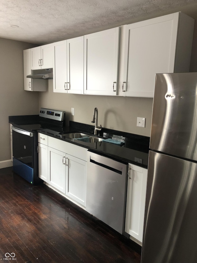 kitchen with a textured ceiling, stainless steel appliances, sink, dark hardwood / wood-style floors, and white cabinetry