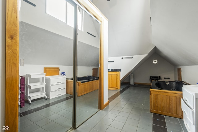 interior space featuring tile patterned flooring and vaulted ceiling