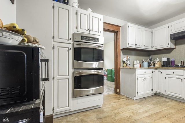 kitchen featuring light hardwood / wood-style floors, white cabinetry, and double oven