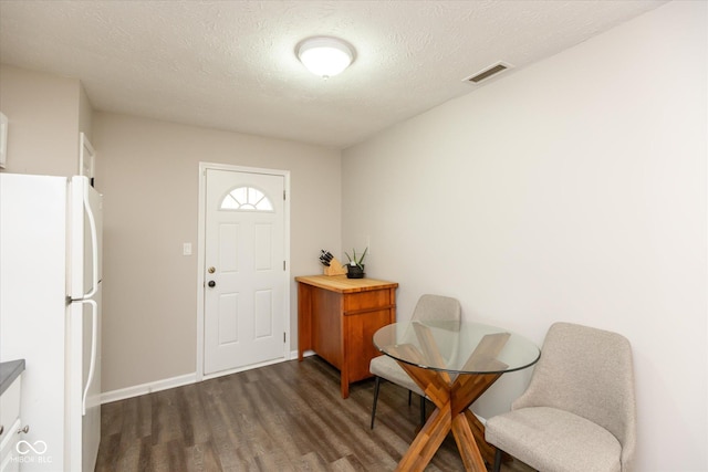 foyer with dark hardwood / wood-style floors and a textured ceiling