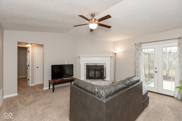 living room featuring french doors, vaulted ceiling, ceiling fan, a textured ceiling, and light colored carpet