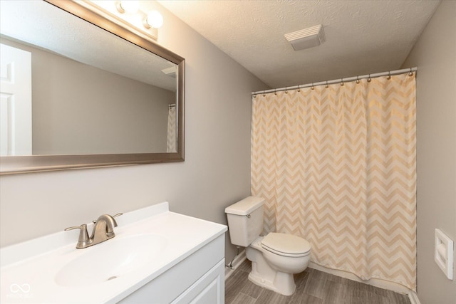 bathroom with vanity, toilet, a textured ceiling, curtained shower, and wood-type flooring