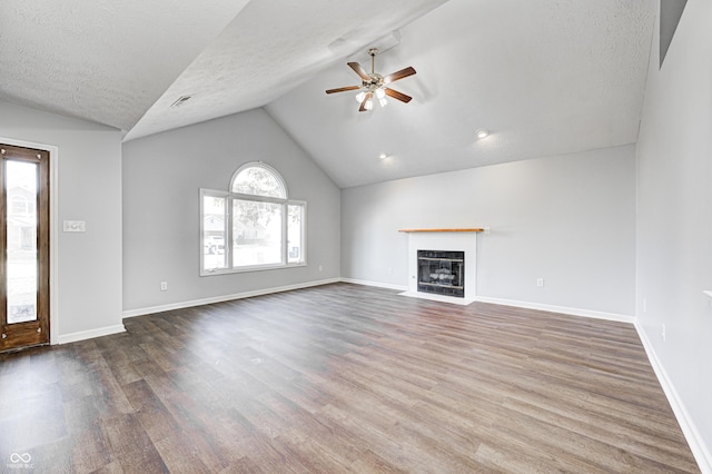 unfurnished living room with a textured ceiling, hardwood / wood-style flooring, vaulted ceiling, and ceiling fan