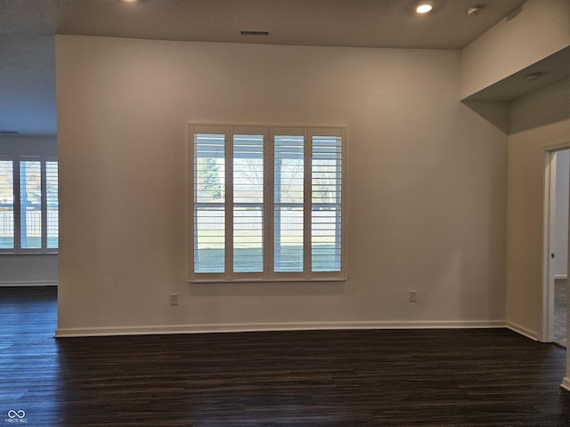 empty room with dark hardwood / wood-style flooring