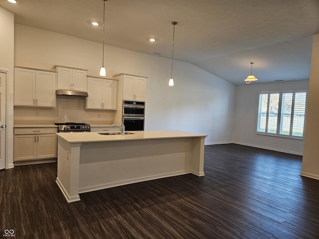 kitchen with dark hardwood / wood-style flooring, an island with sink, pendant lighting, lofted ceiling, and white cabinets