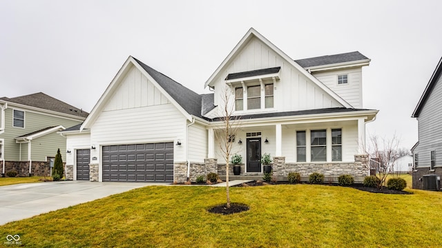 view of front of property with central AC unit, a front yard, and a garage