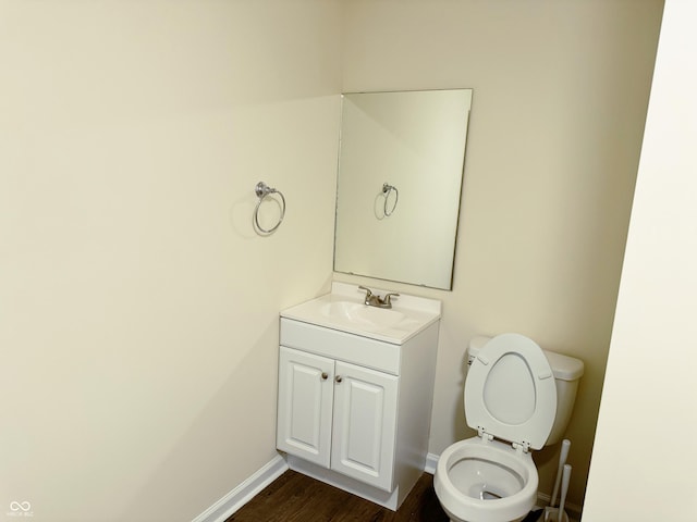 bathroom with vanity, hardwood / wood-style flooring, and toilet