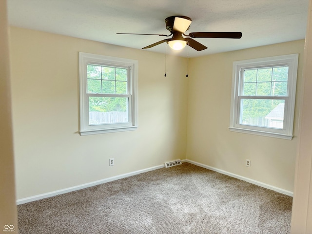 spare room with ceiling fan and carpet