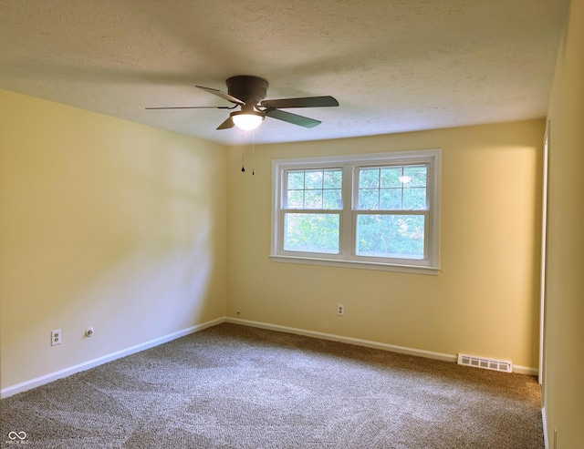 empty room featuring ceiling fan, carpet floors, and a textured ceiling