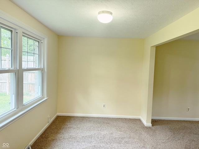 unfurnished room with a textured ceiling and carpet floors