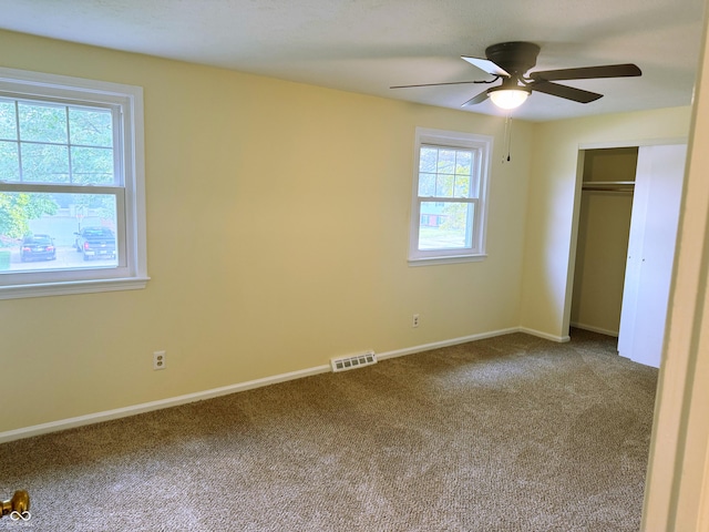 unfurnished bedroom featuring carpet, a closet, and ceiling fan