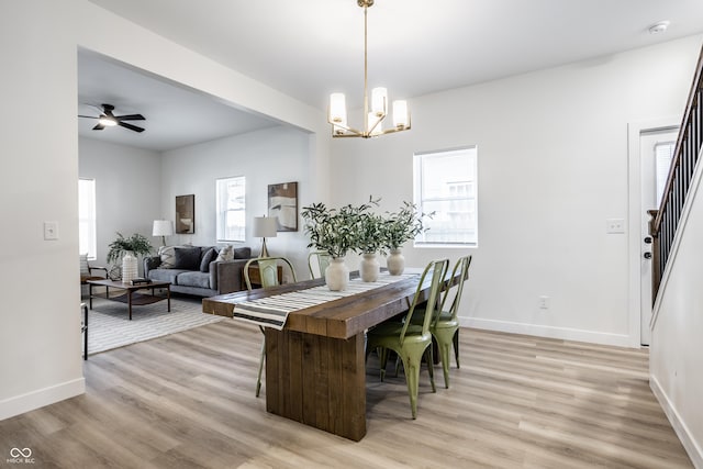 dining room featuring a wealth of natural light, light hardwood / wood-style floors, and ceiling fan with notable chandelier