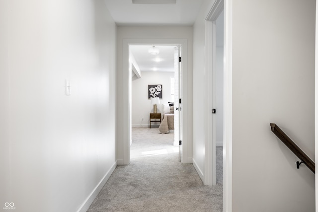 corridor featuring light colored carpet