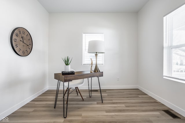 home office with light hardwood / wood-style flooring