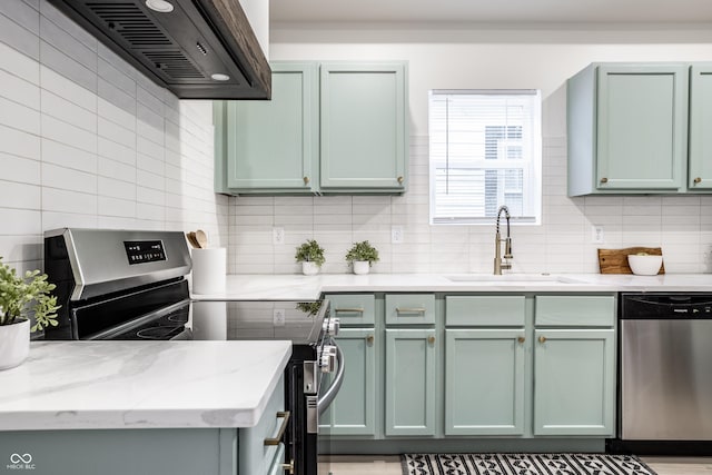 kitchen with sink, premium range hood, stainless steel appliances, and green cabinetry