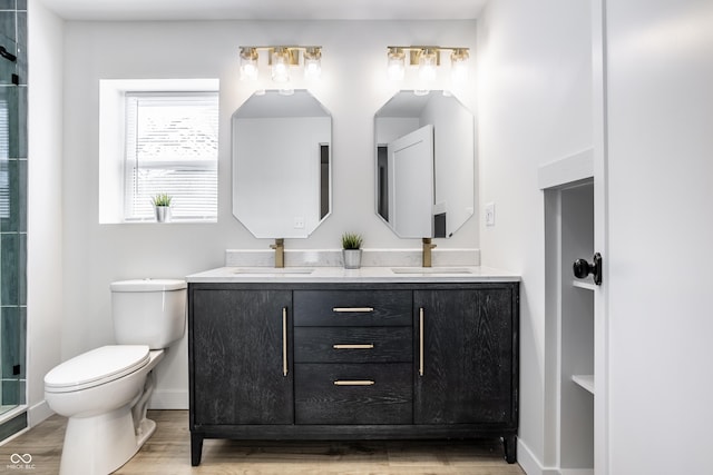 bathroom featuring hardwood / wood-style floors, vanity, toilet, and an enclosed shower