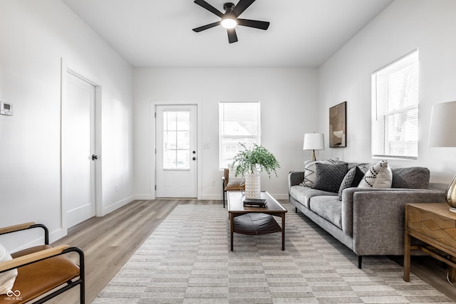 living room with light hardwood / wood-style floors and ceiling fan