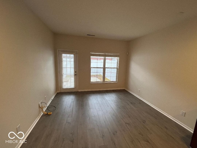 unfurnished room with dark wood-type flooring and a healthy amount of sunlight