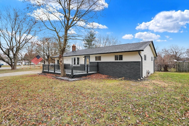 single story home featuring a front yard and a wooden deck