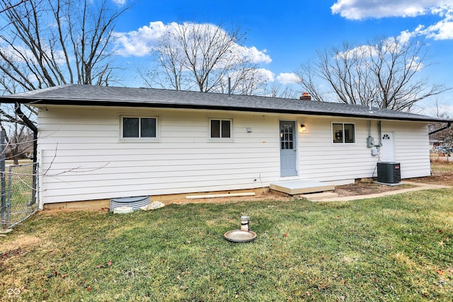 back of property featuring central AC and a lawn