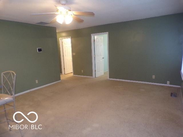 carpeted spare room featuring ceiling fan