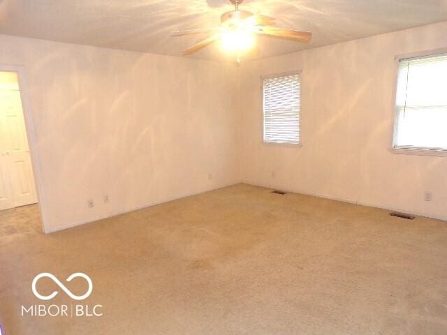 spare room featuring ceiling fan and light colored carpet