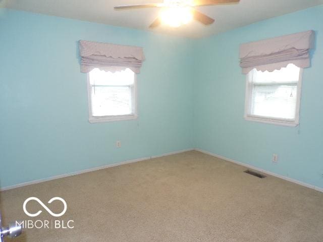 carpeted spare room featuring ceiling fan