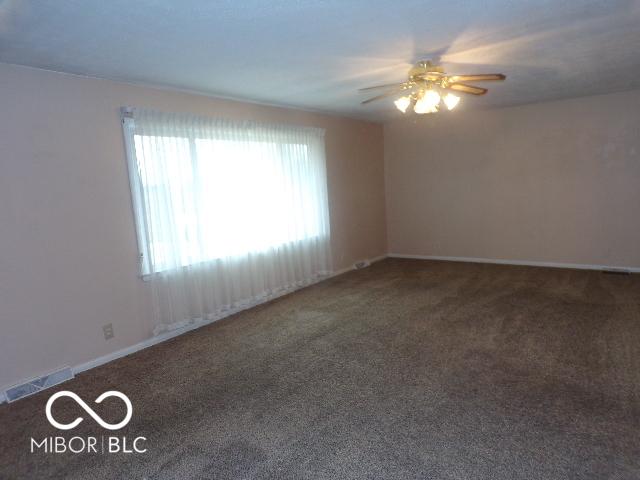 carpeted empty room with ceiling fan