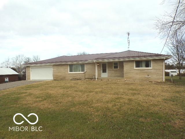 single story home featuring a garage and a front yard