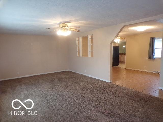 unfurnished room with carpet flooring and ceiling fan