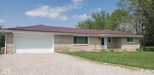 5956 N US Highway 31, Seymour, IN 47274 - single story home featuring gravel driveway, stone siding, a front yard, a garage, and metal roof