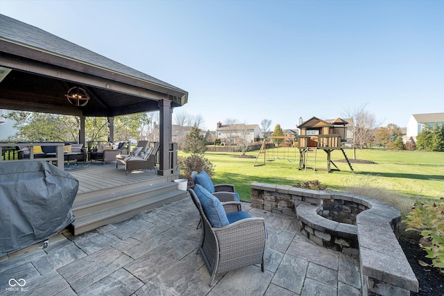 view of patio featuring an outdoor living space, a deck, a playground, and a grill