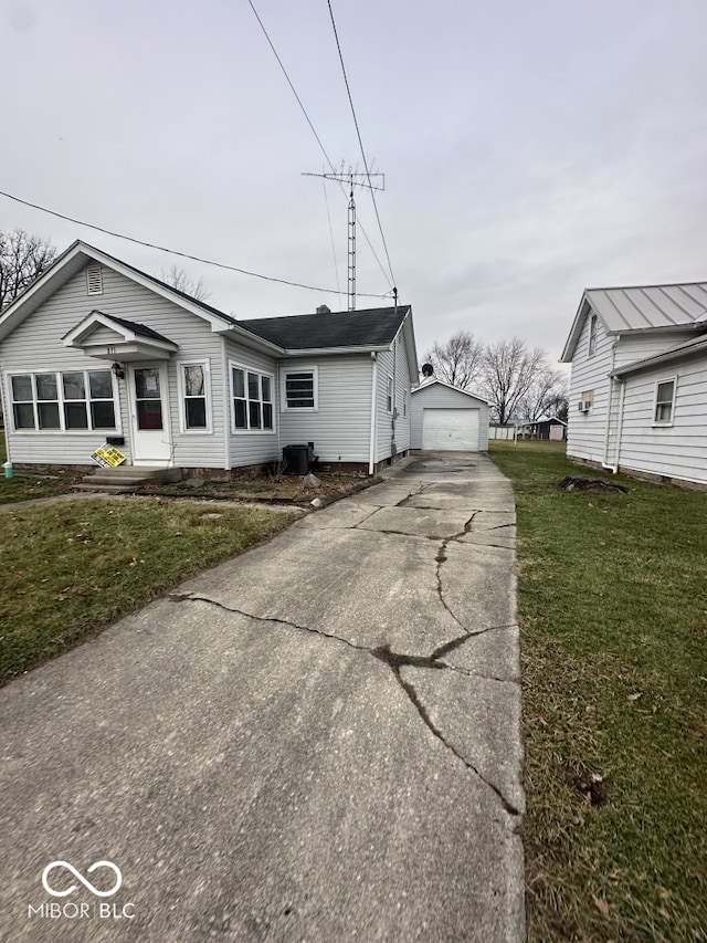 view of front of home with an outbuilding, a garage, and a front lawn