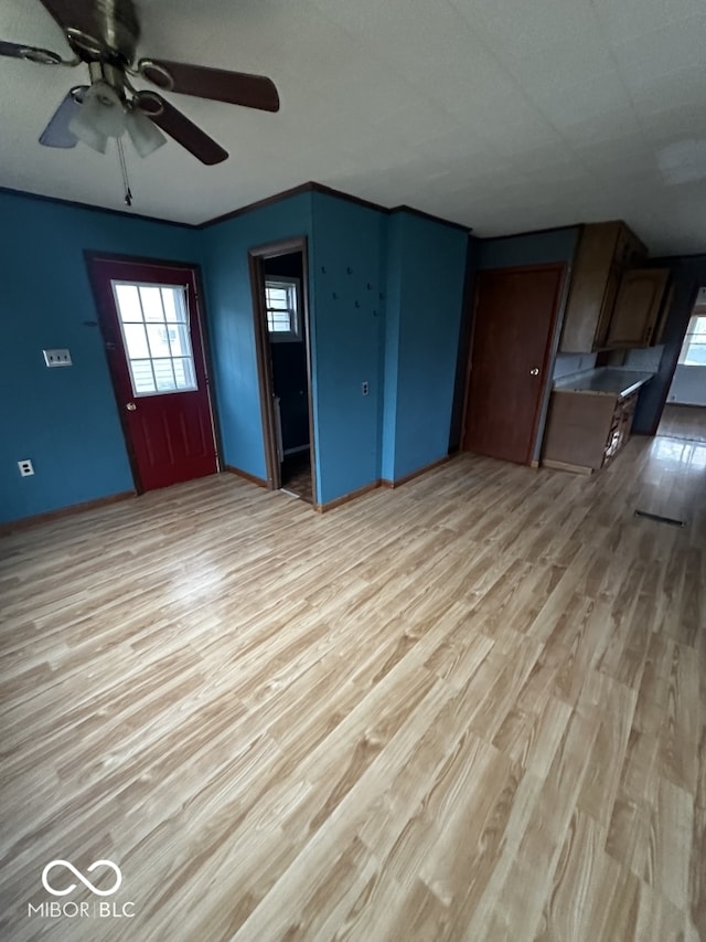 unfurnished living room with light wood-type flooring and ceiling fan