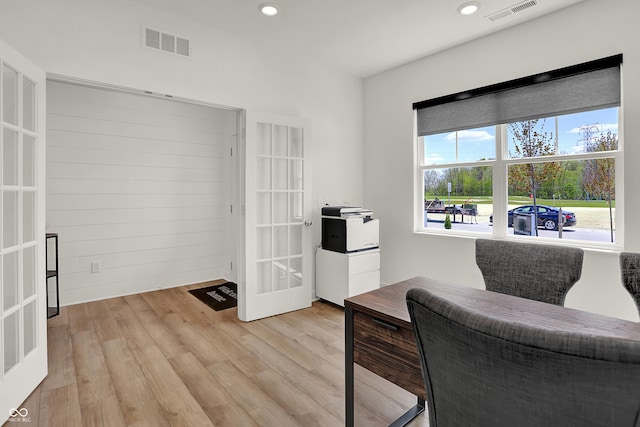 living area with light hardwood / wood-style floors and french doors