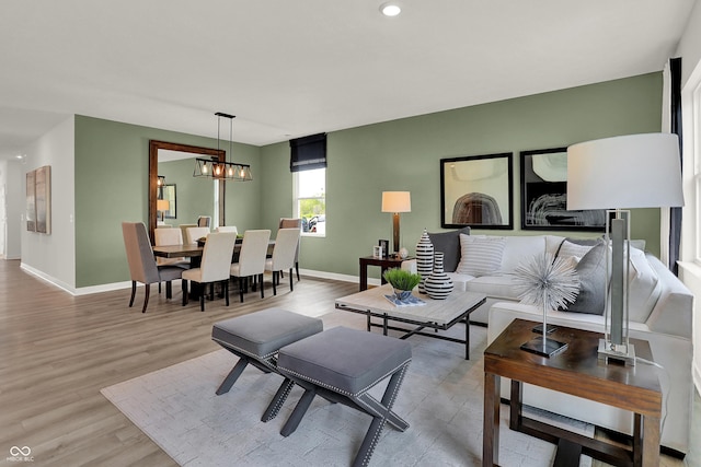 living room with a chandelier and light hardwood / wood-style flooring