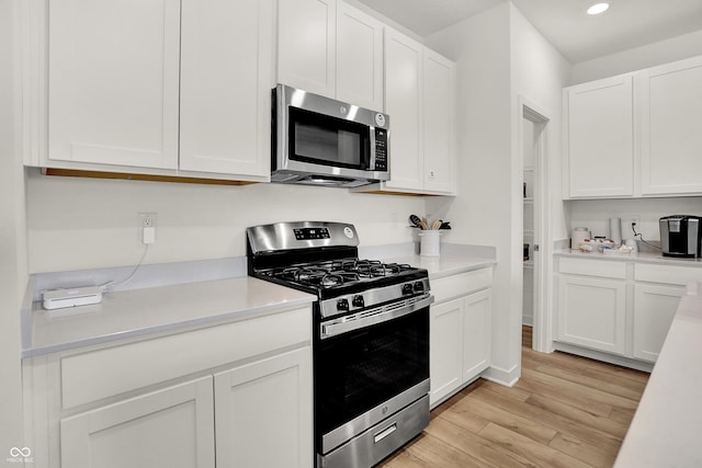 kitchen featuring white cabinets, light hardwood / wood-style floors, and appliances with stainless steel finishes