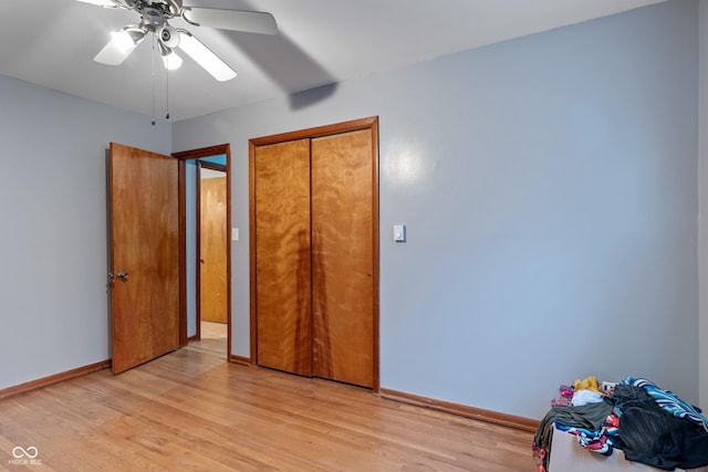 unfurnished bedroom with light hardwood / wood-style flooring, a closet, and ceiling fan