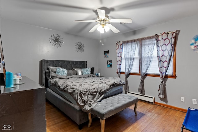 bedroom featuring hardwood / wood-style flooring, a baseboard radiator, and ceiling fan