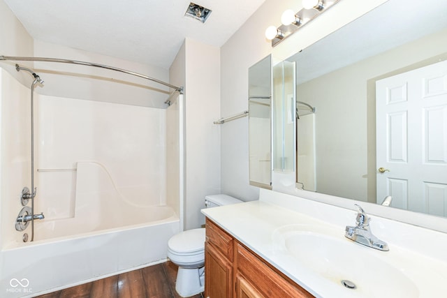 full bathroom featuring hardwood / wood-style floors, a textured ceiling, toilet, vanity, and shower / bathtub combination