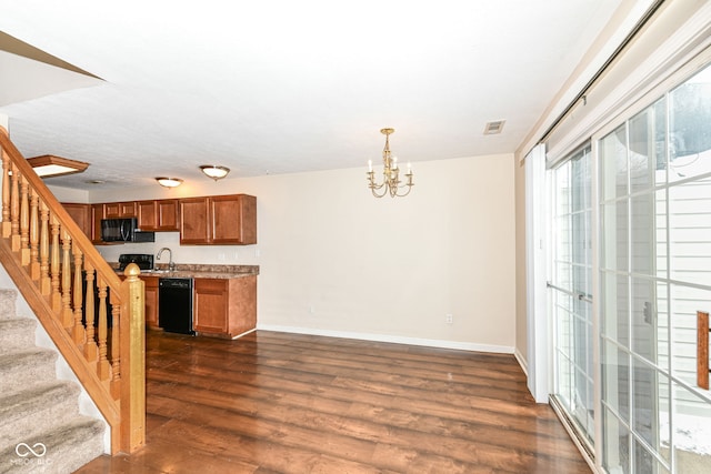 kitchen featuring dark wood-type flooring, sink, black appliances, decorative light fixtures, and an inviting chandelier