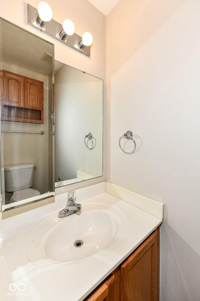 bathroom featuring vanity and toilet