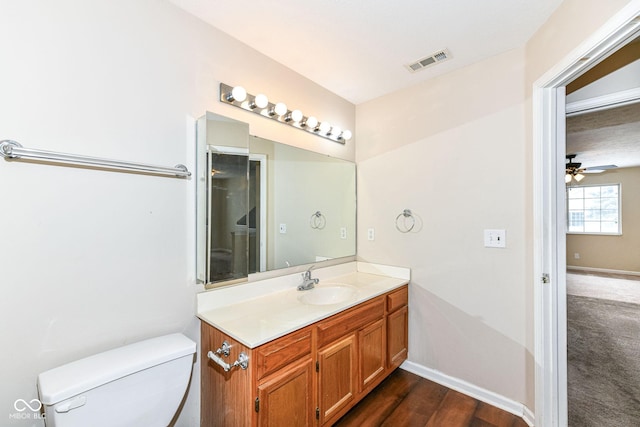 bathroom featuring ceiling fan, hardwood / wood-style floors, vanity, and toilet