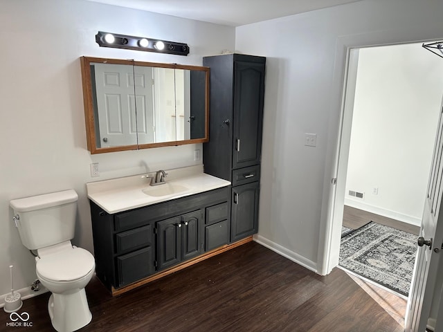 bathroom with hardwood / wood-style floors, vanity, and toilet