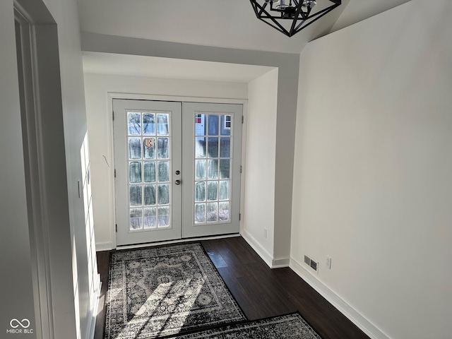 doorway to outside featuring french doors, dark hardwood / wood-style floors, and an inviting chandelier