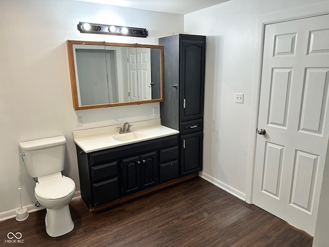 bathroom with vanity, toilet, and wood-type flooring