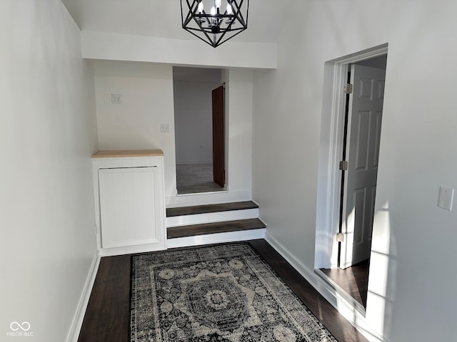 hall featuring wood-type flooring and a notable chandelier