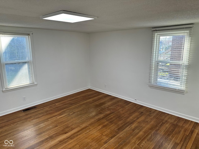 spare room featuring hardwood / wood-style floors and a textured ceiling