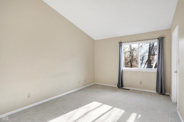 carpeted spare room with lofted ceiling