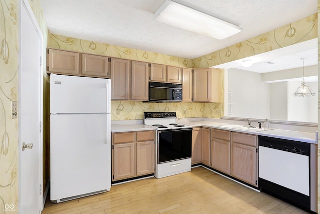 kitchen featuring white appliances, a textured ceiling, sink, pendant lighting, and light hardwood / wood-style floors